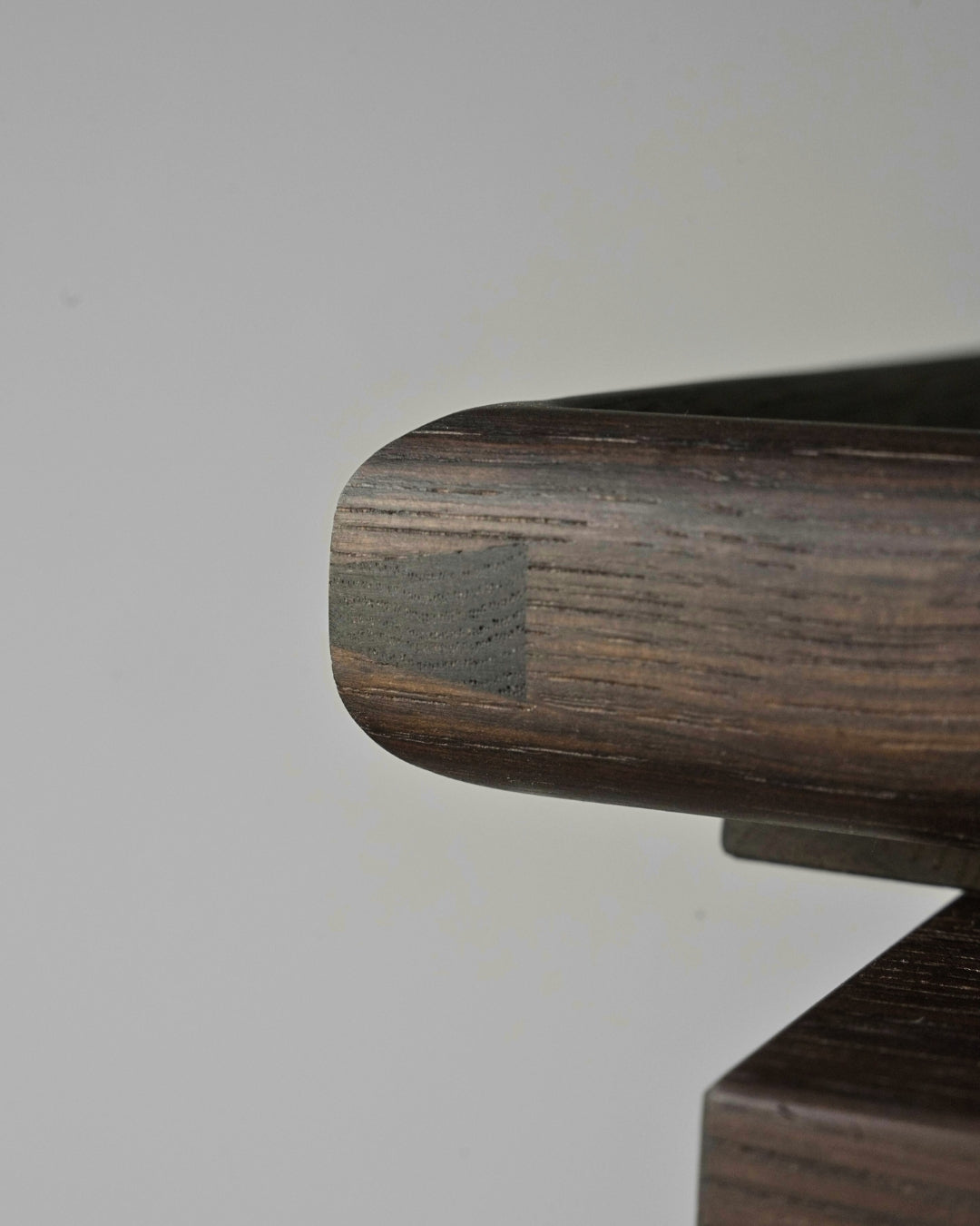 Close-up of the rounded fumed oak frame, showing an exposed dovetail at the corner