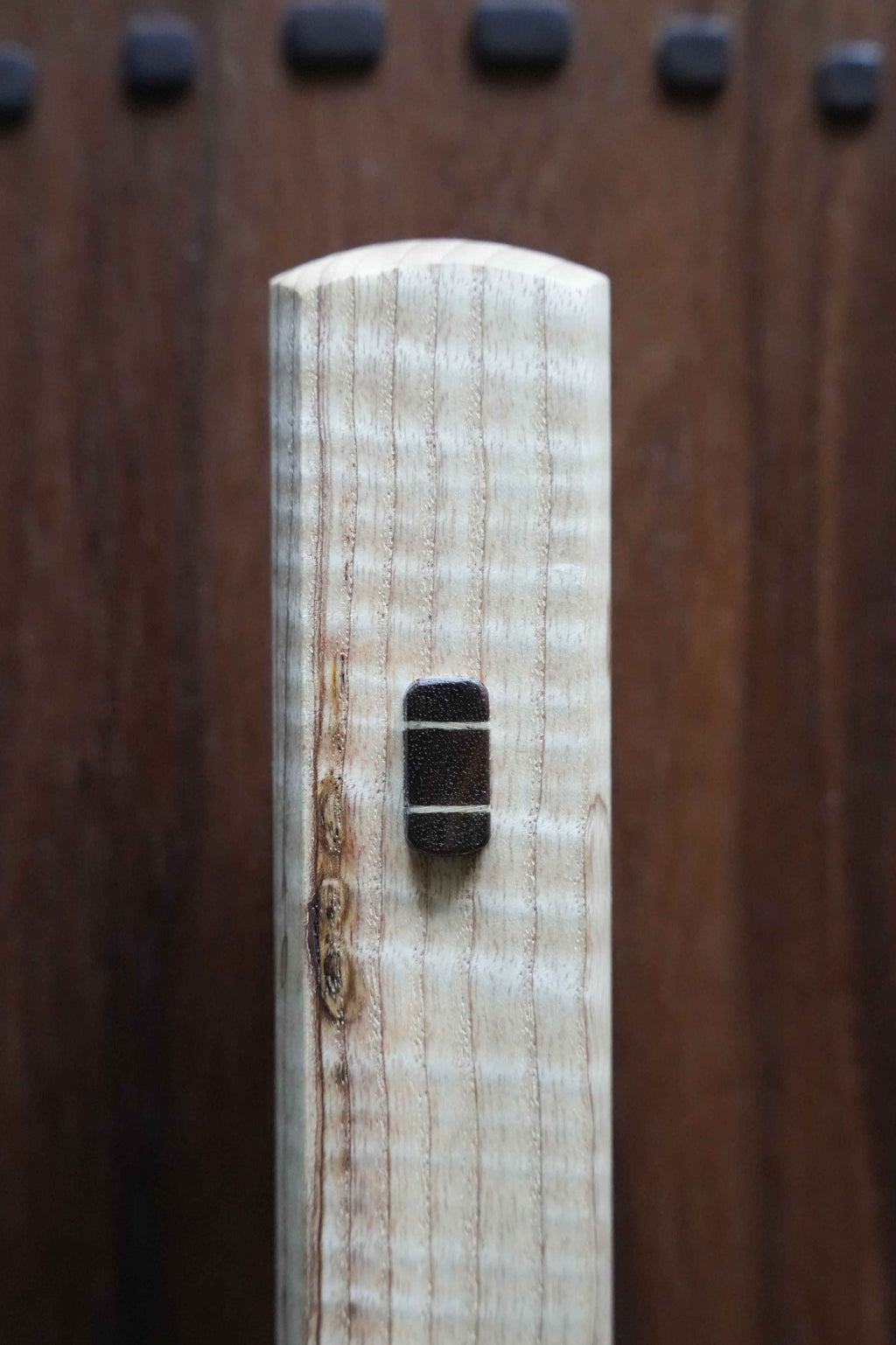 Close-up of a wooden object with a dark spot on a wooden background