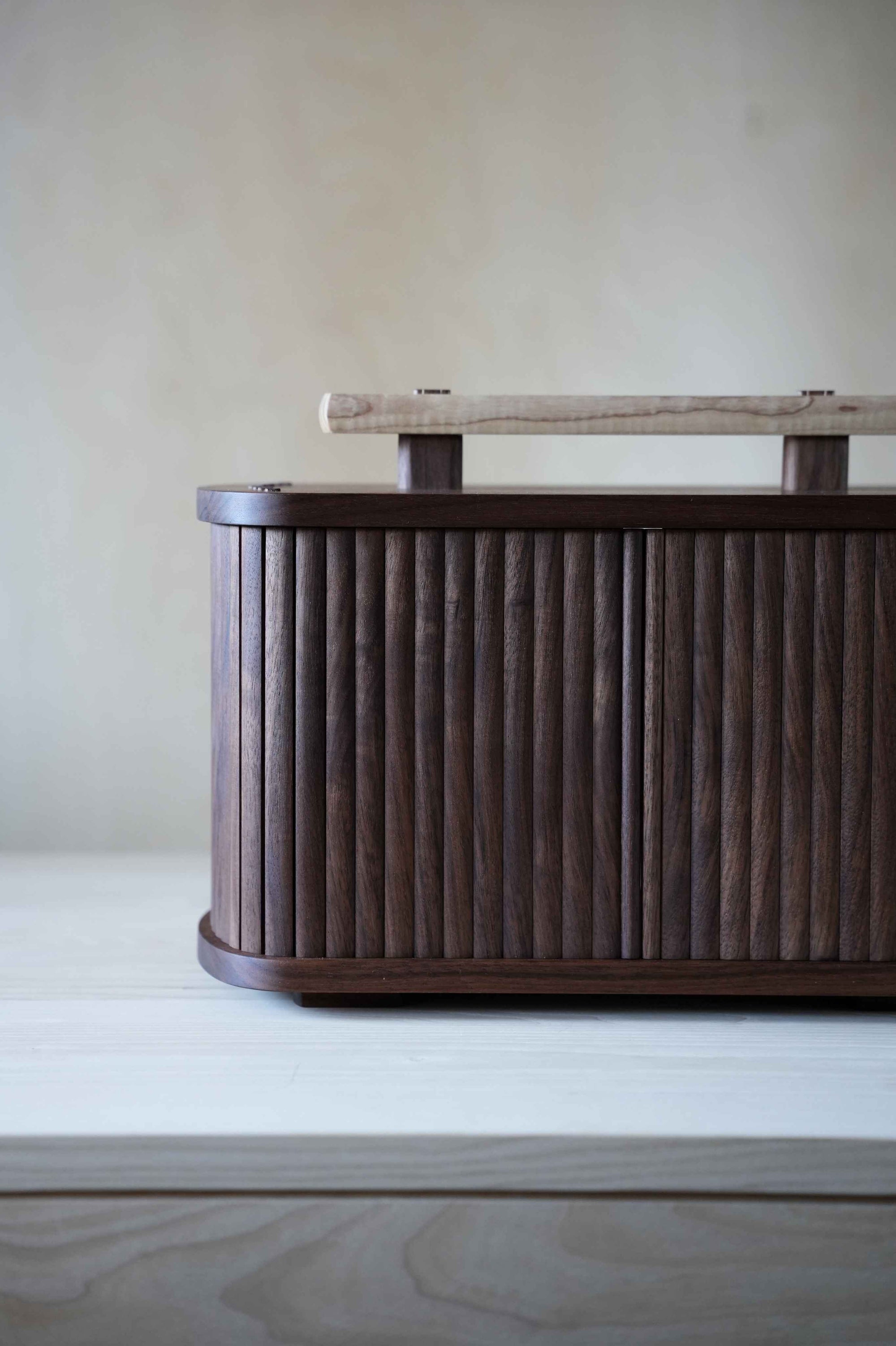 Wooden box with tambour doors on a wooden surface