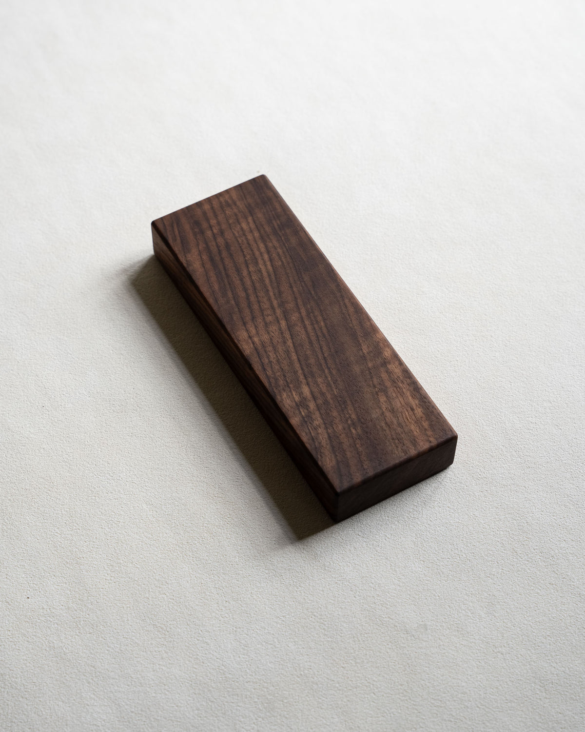 Closed pill box in dark walnut with visible figure in the grain