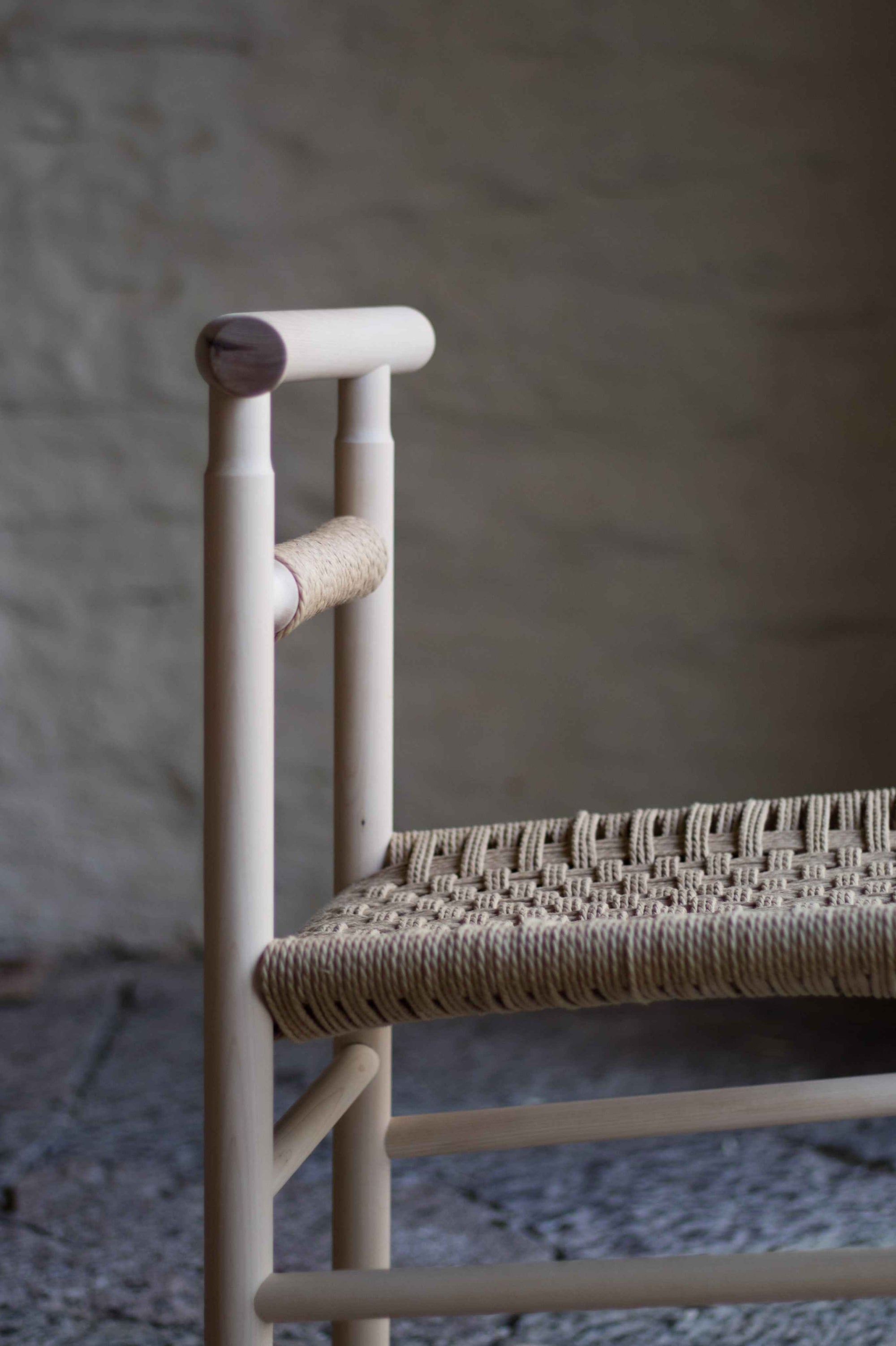 Chair with woven seat and wooden frame against a neutral background