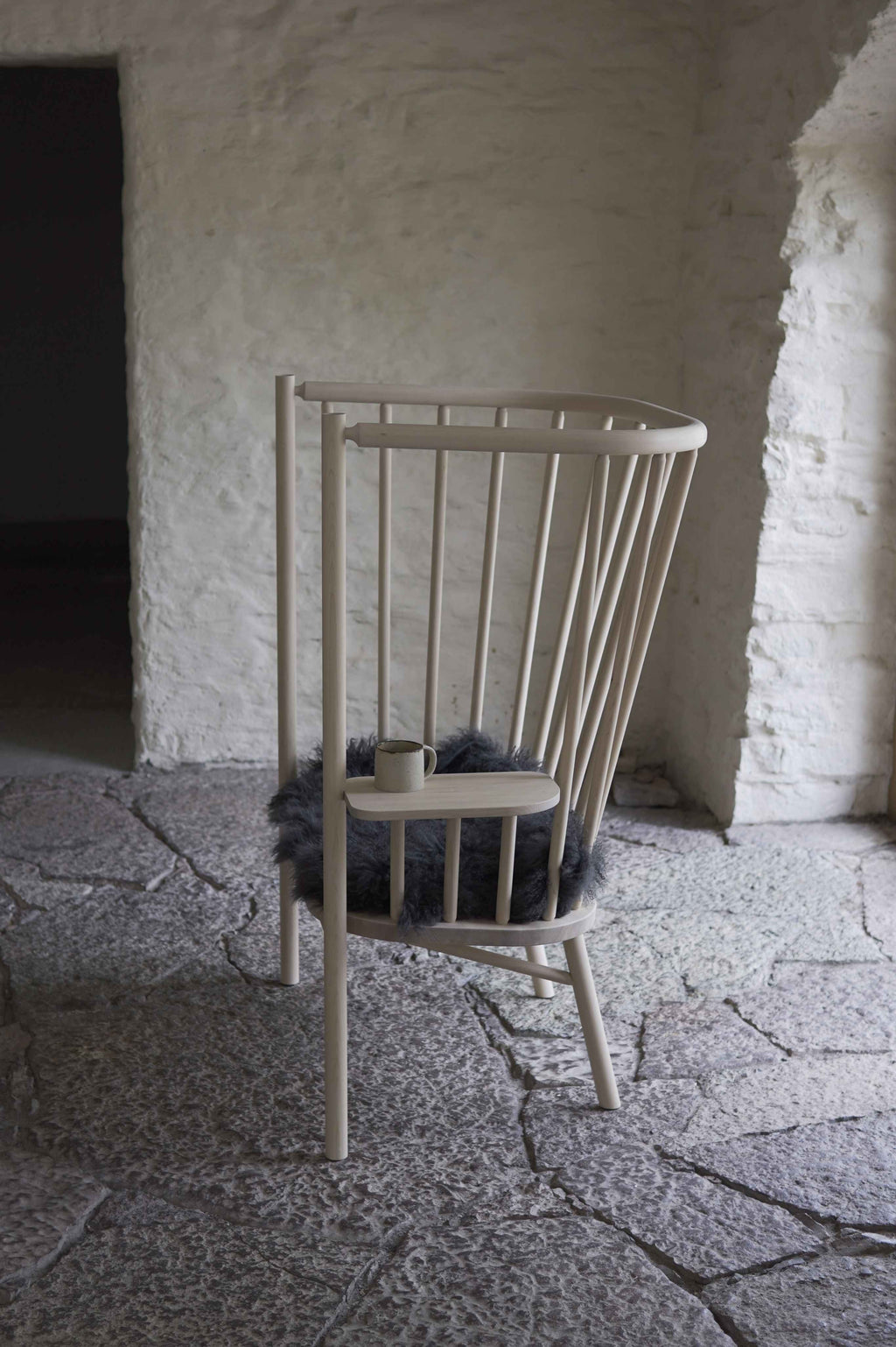 Wooden chair with a cushion in a rustic stone-walled room
