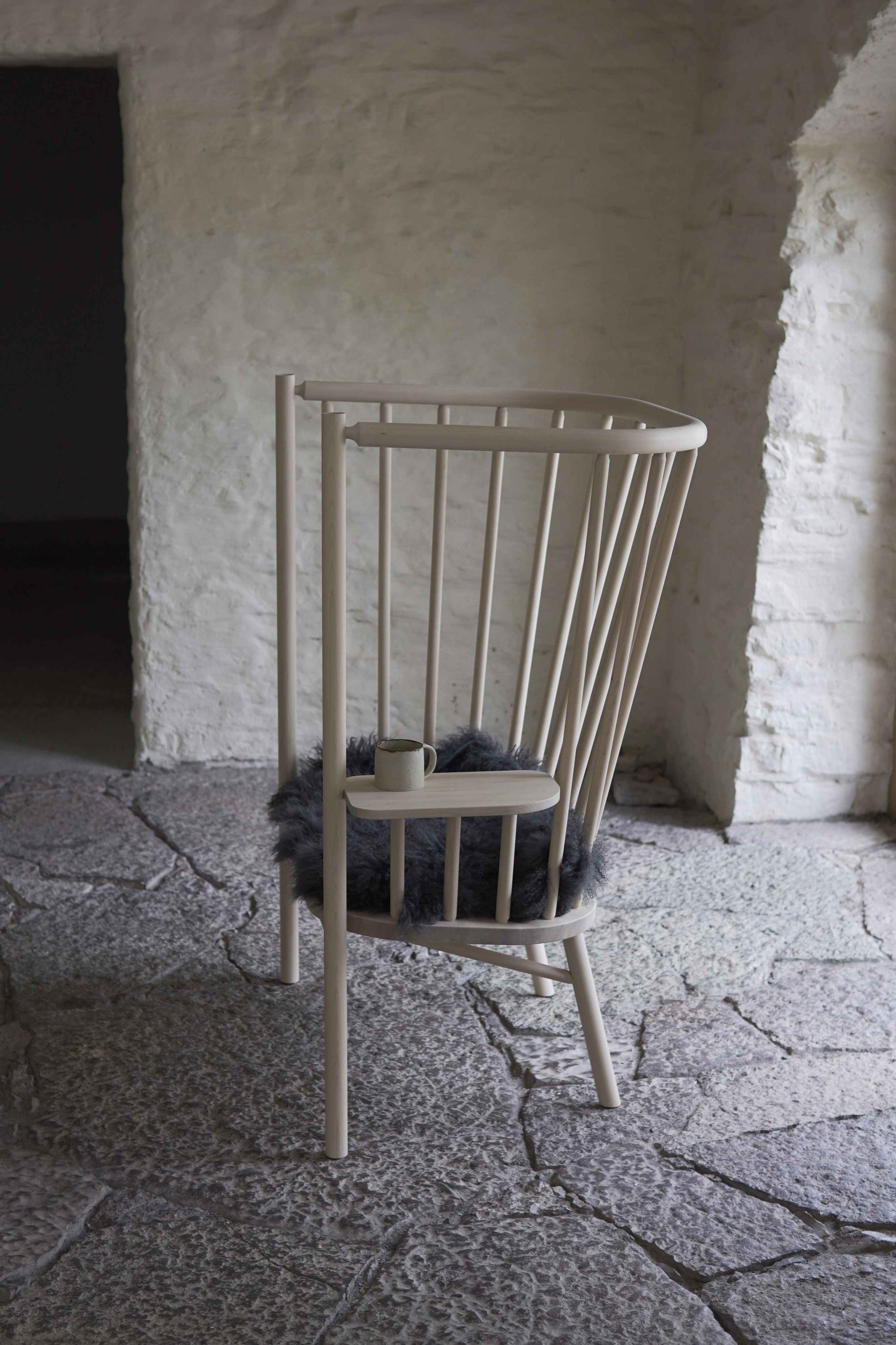 Wooden chair with a cushion in a rustic stone-walled room