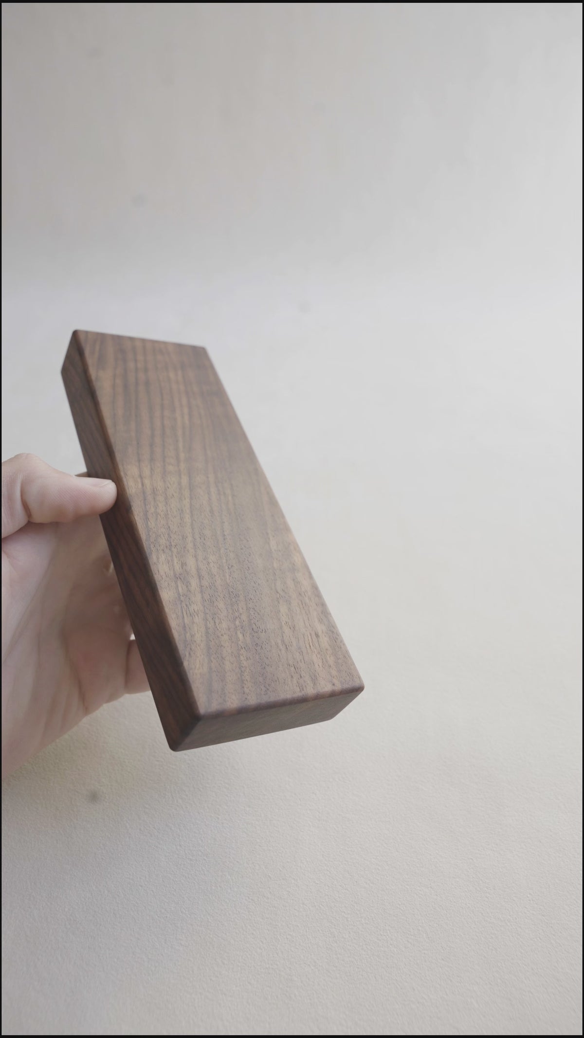 Video showing a hand sliding open the magnetic walnut pill box to reveal the masur birch tray